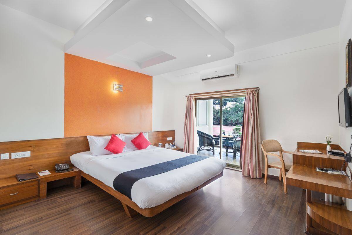 Une chambre d’hôtel avec un grand lit, un bureau et une vue sur l’extérieur.