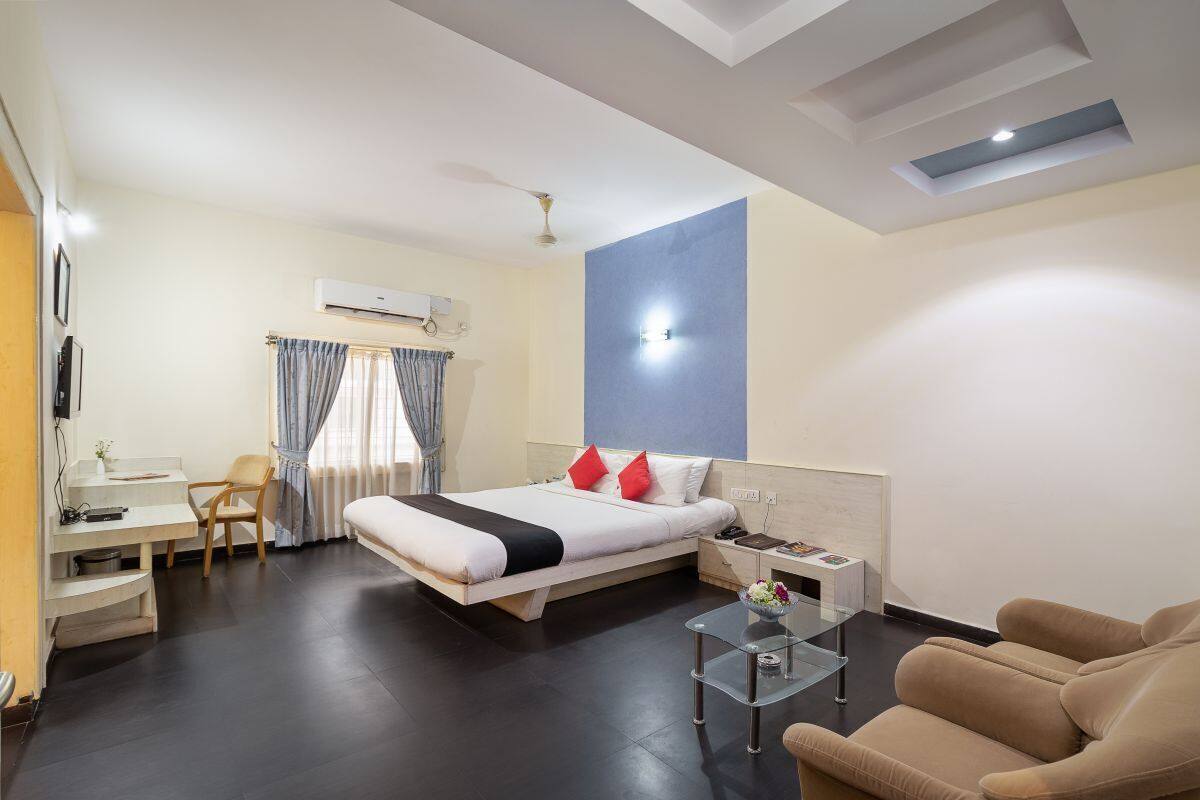 Une chambre d’hôtel moderne équipée d’un lit, d’un bureau, d’une chaise, d’un canapé et d’une petite table.