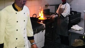Una cocina profesional con electrodomésticos de acero inoxidable y una estufa grande con llamas.