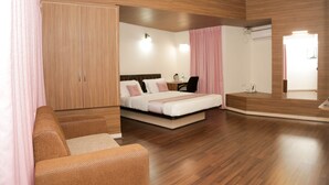 Un dormitorio moderno con un armario de madera, una cama con cabecero, un escritorio y un espejo.