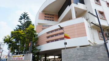 A modern hotel with a curved facade, multiple balconies, and a flag.