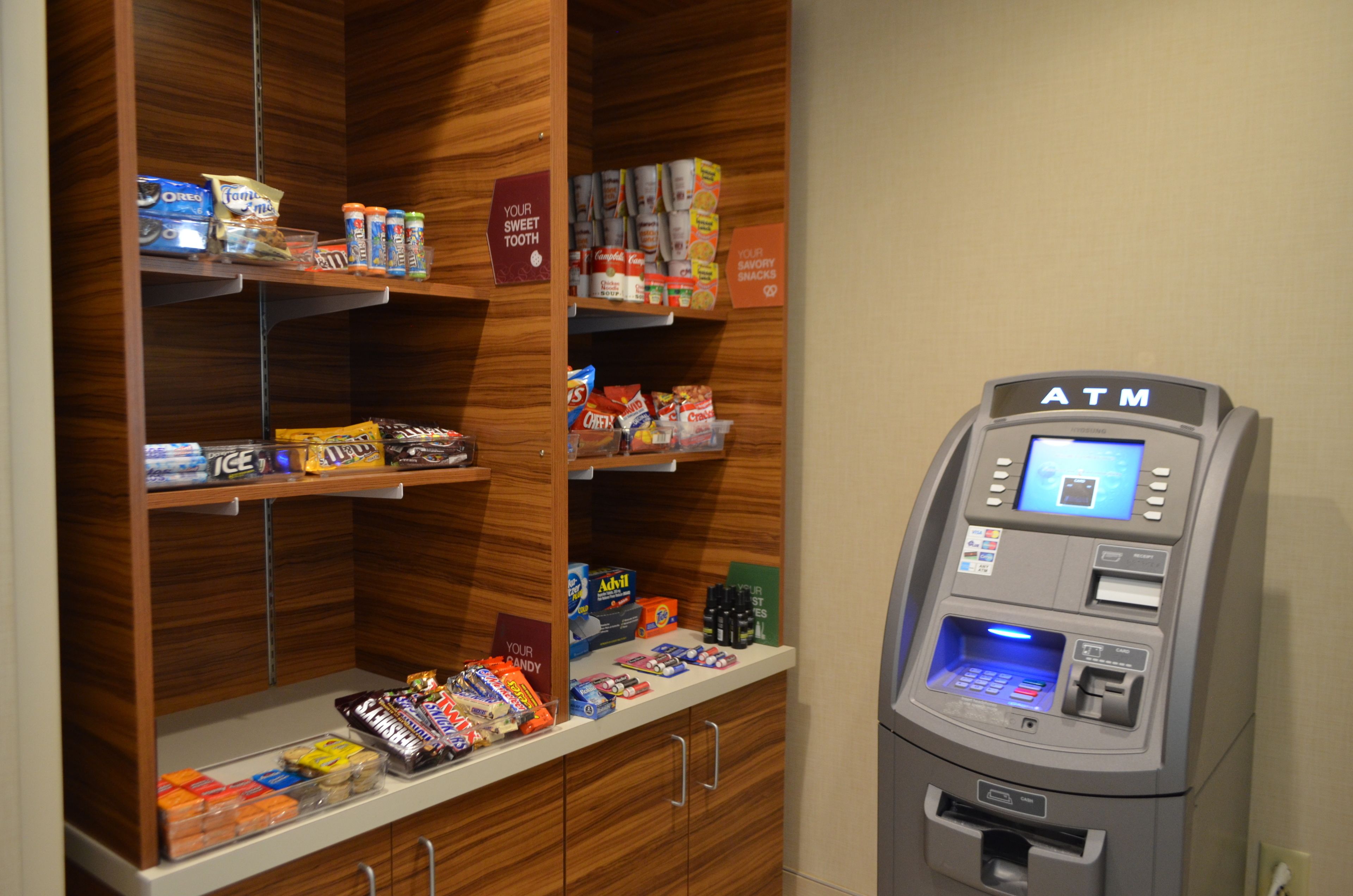 Una exhibición de bocadillos con diversos alimentos empacados y un cajero automático.