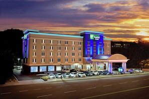 Un hôtel doté d'une enseigne Holiday Inn Express & Suites bien visible, de nombreux espaces de stationnement et d'une entrée bien éclairée.