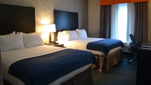 Hotellihuone, jossa on kaksi sänkyä, työpöytä ja tuoli.