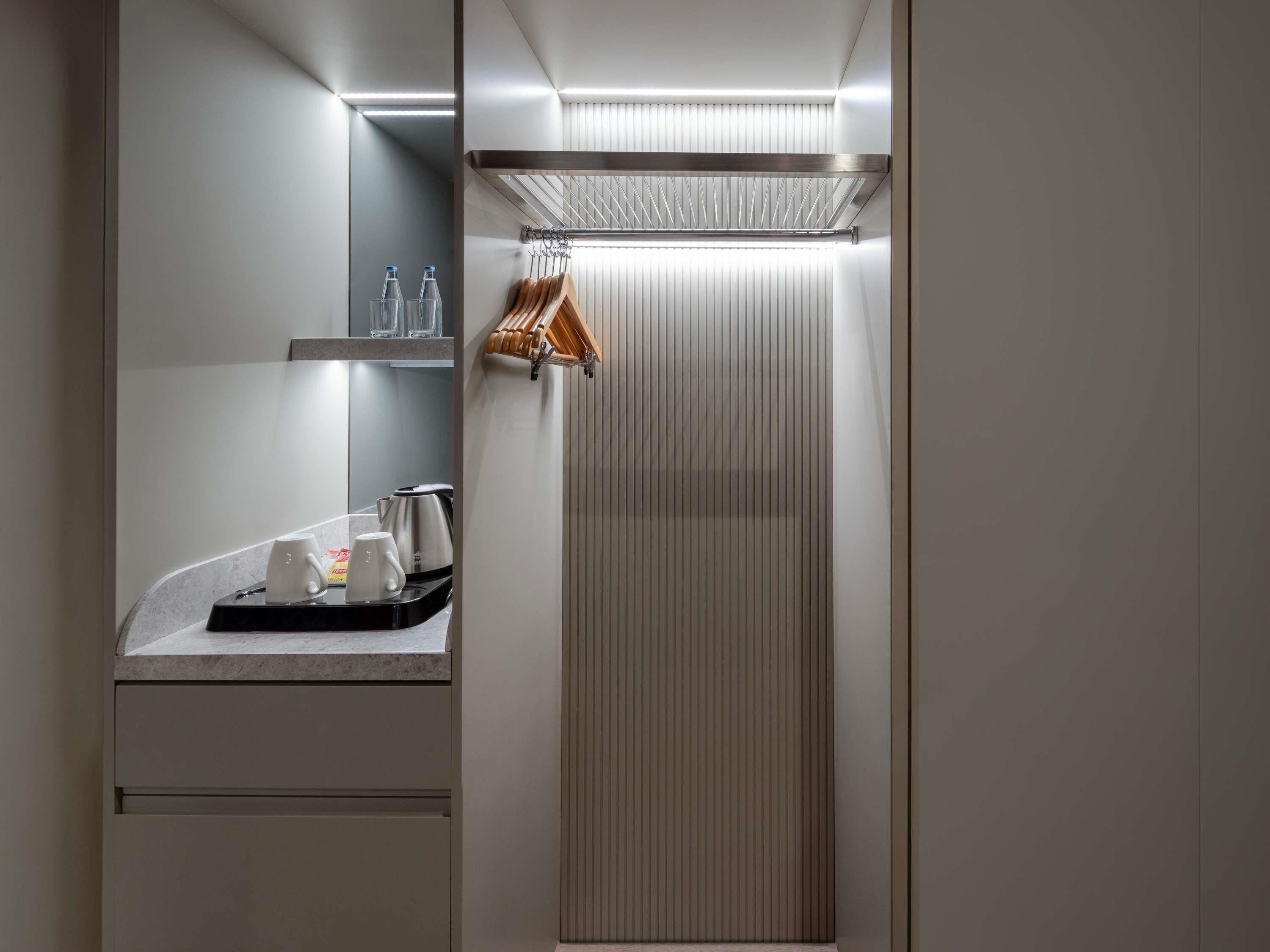 Un baño moderno con lavamanos, espejo, toallero y zona de ducha.