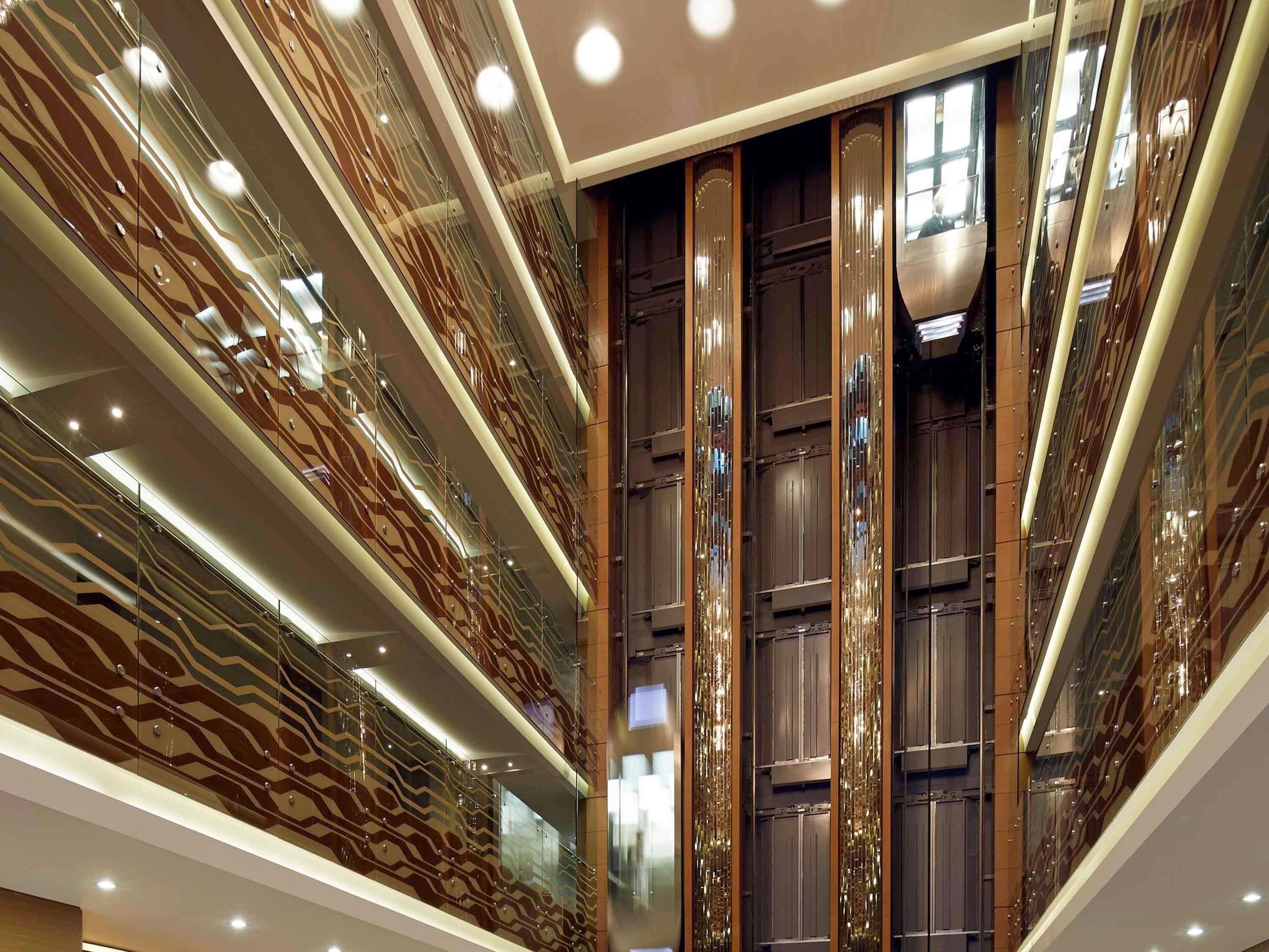 A modern interior with reflective surfaces and a central column.