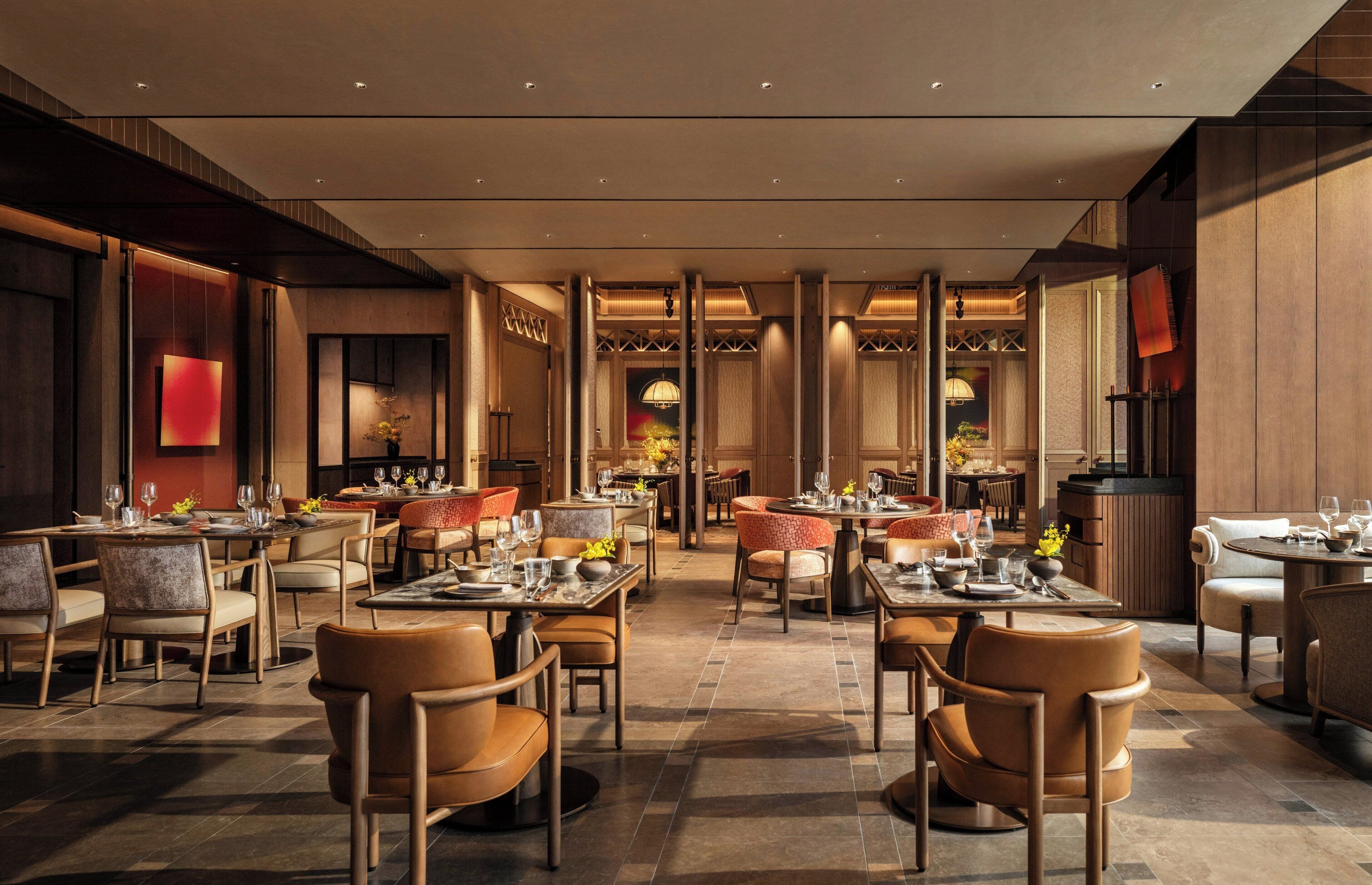 A spacious restaurant with multiple dining areas, high ceilings, and modern decor.