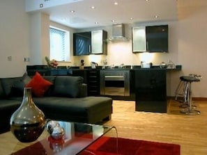 A modern apartment with a living room, kitchen, and dining area.