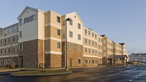 A Staybridge Suites hotel with a brick facade, multiple windows, and a covered entrance. - Staybridge Suites Philadelphia- Montgomeryville by IHG (North Wales)