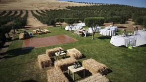 An outdoor event space with tables set up for dining, hay bales, and a paved area. - The Purple Orchid Wine Country Resort & Spa (Livermore)