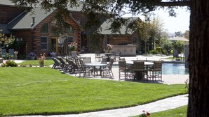 A log cabin with a patio area featuring outdoor furniture and a swimming pool. - The Purple Orchid Wine Country Resort & Spa (Livermore)