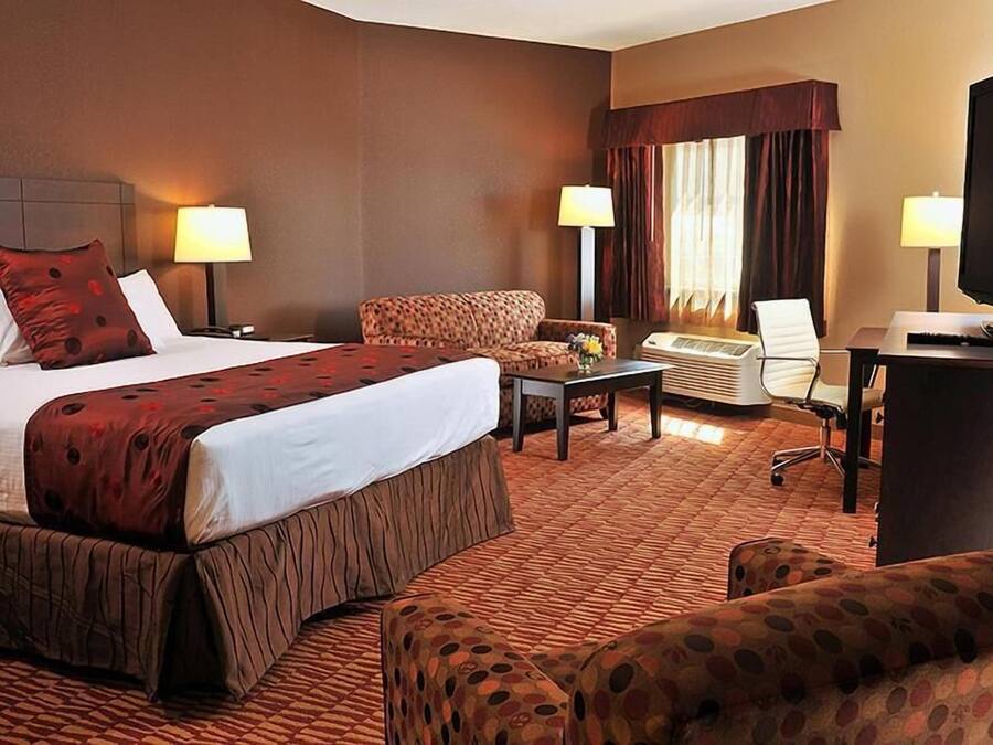 Une chambre d’hôtel avec un grand lit, un canapé, un bureau et une télévision.