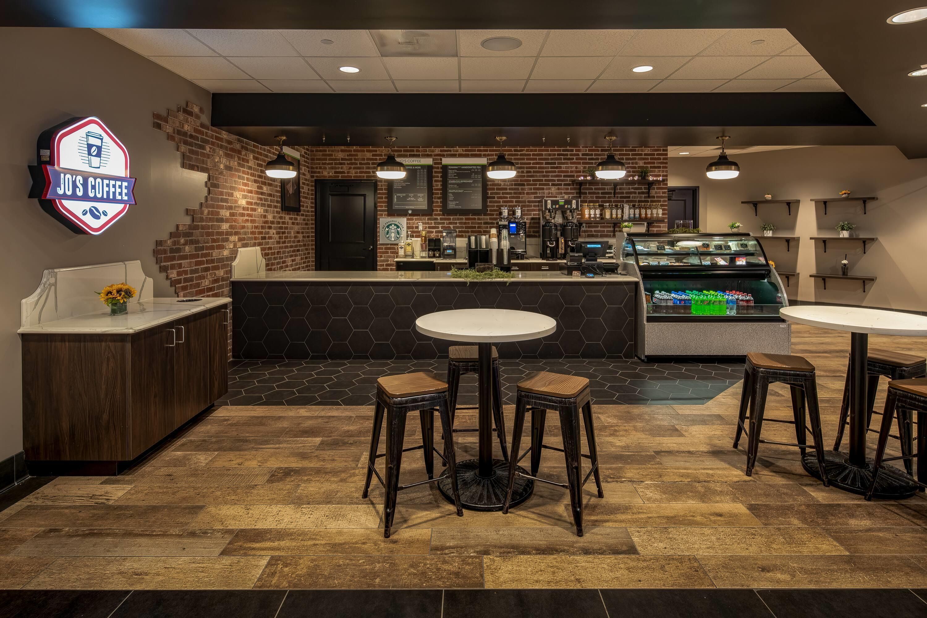 Een café interieur met een toonbank, krukken, een menubord en een Starbucks logo.