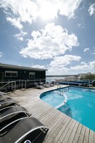 Una piscina al aire libre, sillones reclinables de piscina