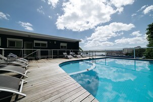 Una piscina al aire libre, tumbonas