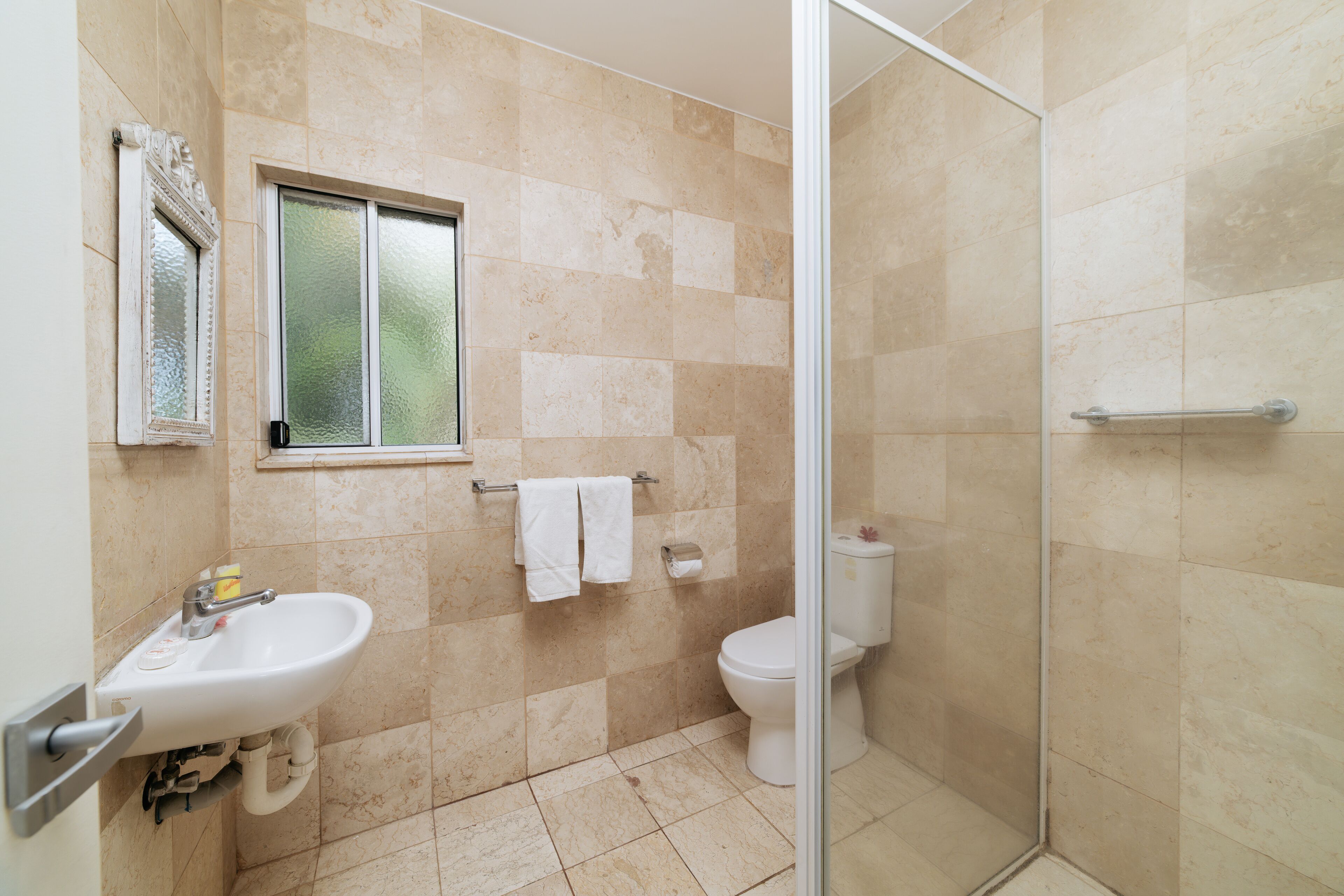 Un baño con lavamanos, inodoro y ducha.