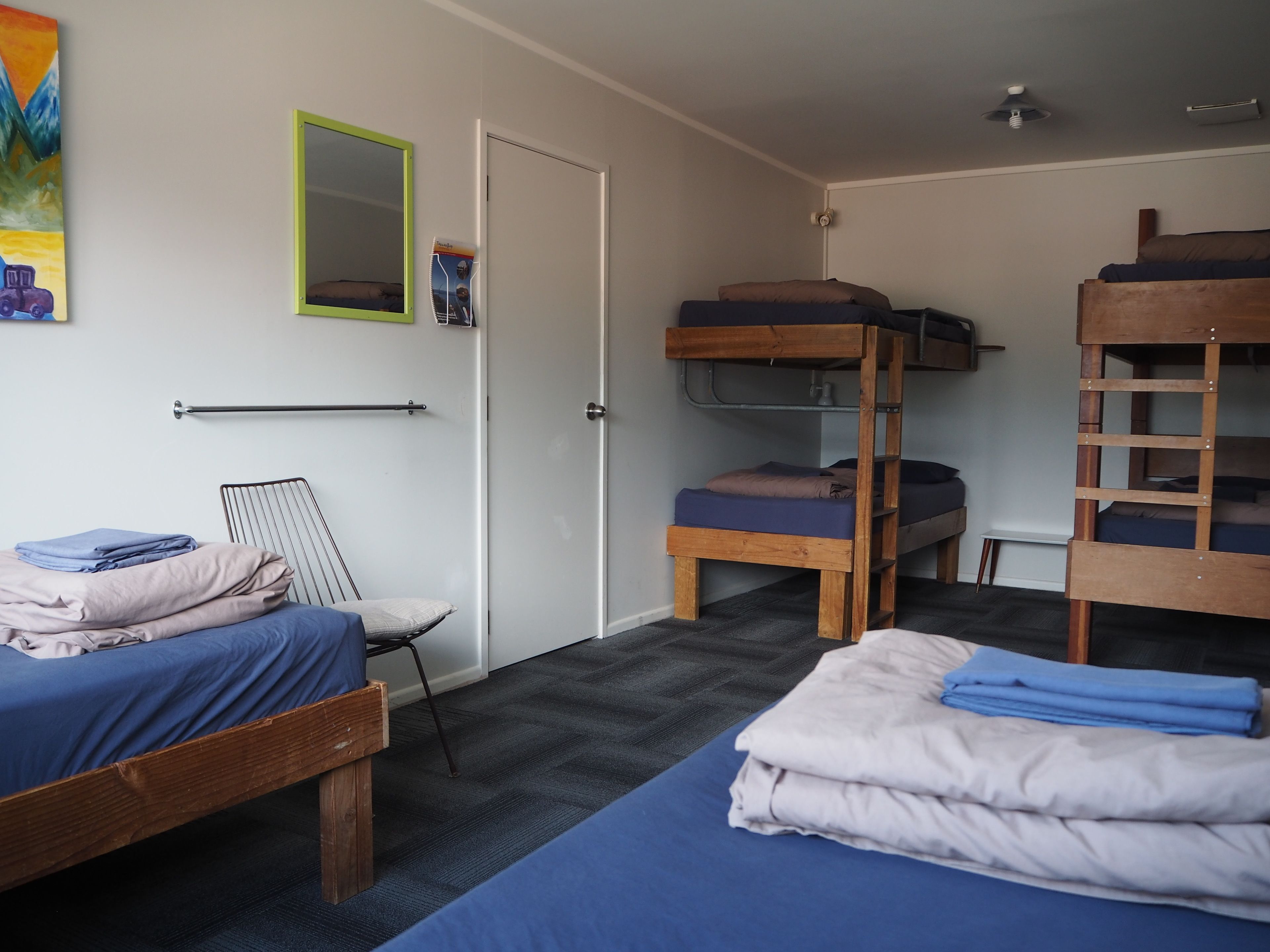 Un dormitorio con literas, un escritorio pequeño y una silla.