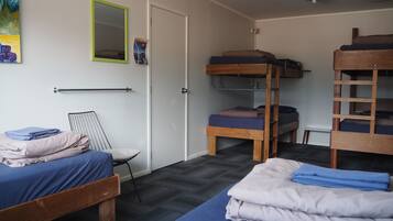 Un dormitorio con literas, un escritorio pequeño y una silla.