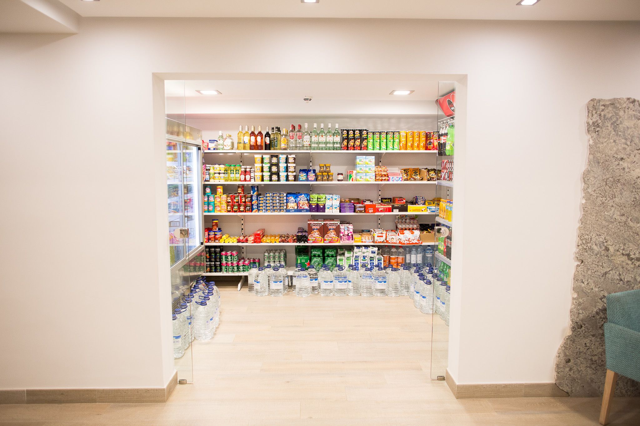 A store with shelves stocked with various products including beverages, snacks, and household items.