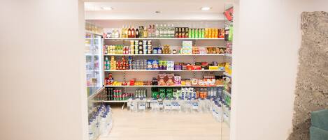 A store with shelves stocked with various products including beverages, snacks, and household items.