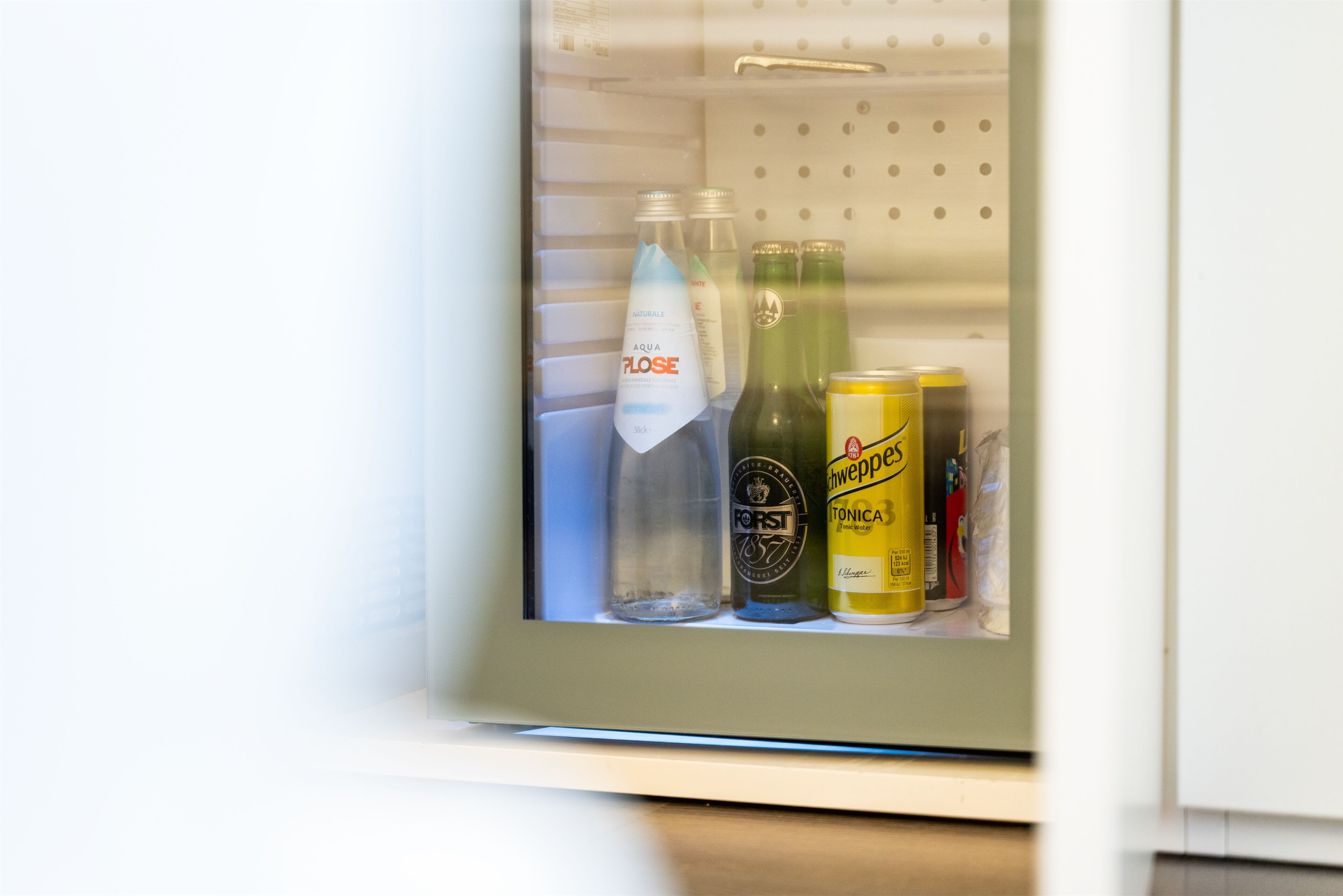 A refrigerator door with bottles and cans.