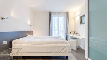 Une chambre moderne avec un lit, une table de chevet et une cloison en verre.