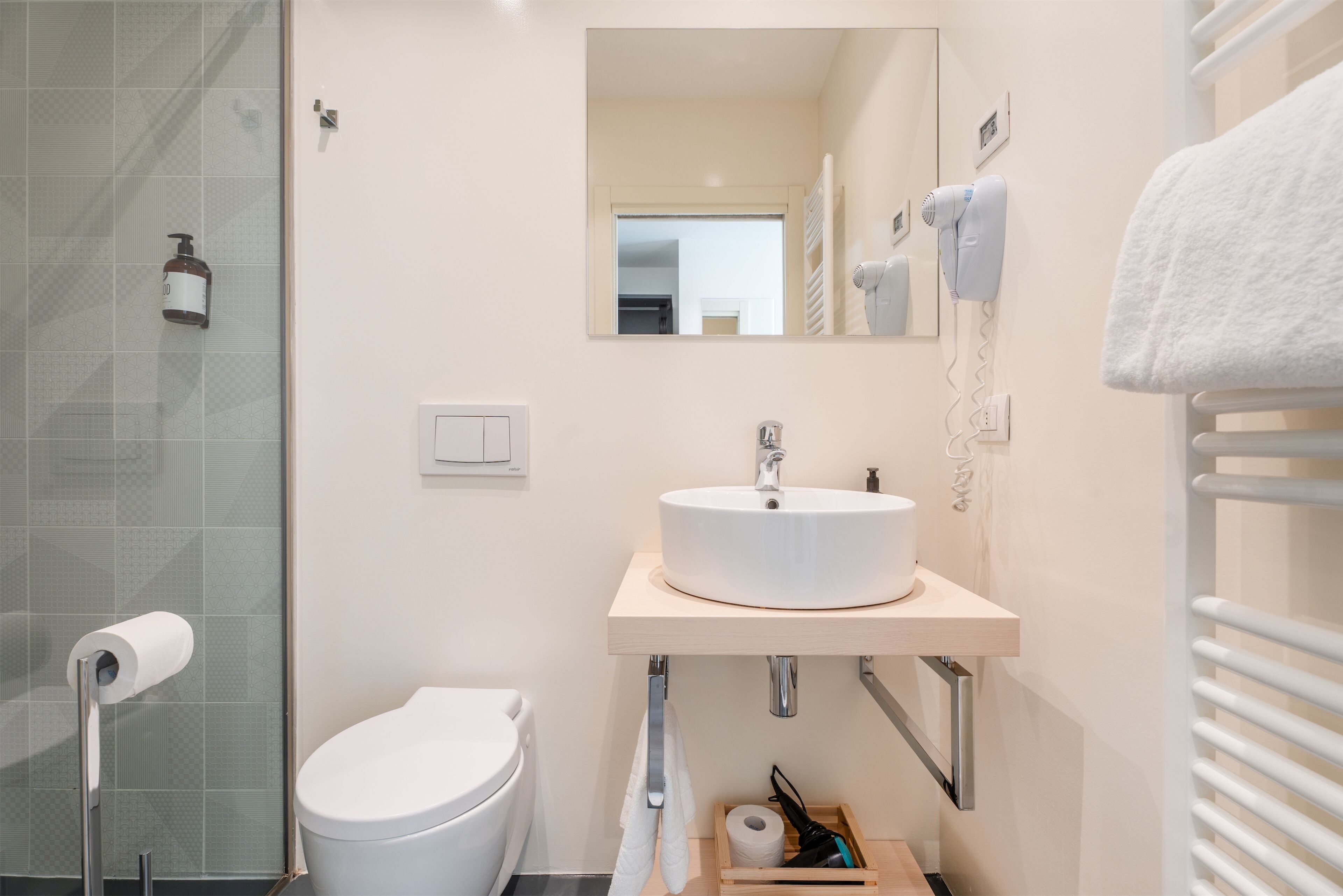 A modern bathroom with a toilet, sink, and shower.