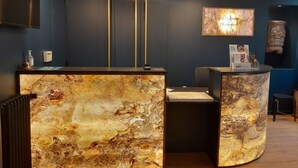 A reception desk with a marble top, a digital screen, and a sign for Brit Hotel. - Brit Hotel Les Comtes de Champagne Centre Historique (Troyes)