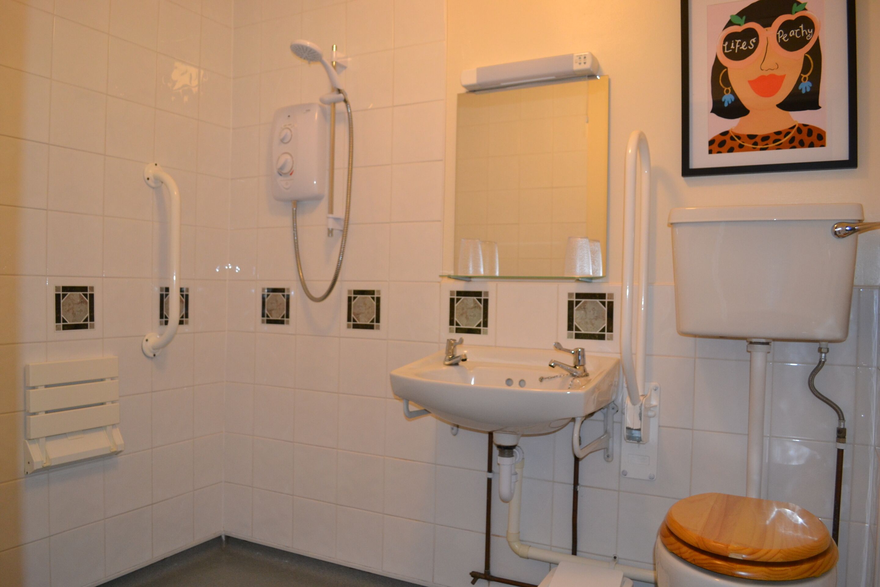 Un baño con lavamanos blanco, espejo, inodoro y ducha.