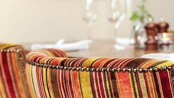 Un comedor con sillas tapizadas a rayas y una mesa de madera.