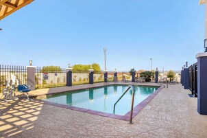 Una piscina al aire libre, sillones reclinables de piscina