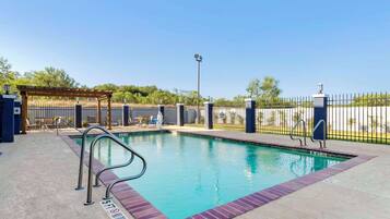 Una piscina al aire libre, sillones reclinables de piscina