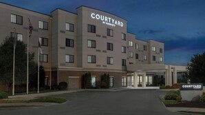 Un hotel Courtyard by Marriott con fachada moderna, varios accesos y un estacionamiento bien cuidado.