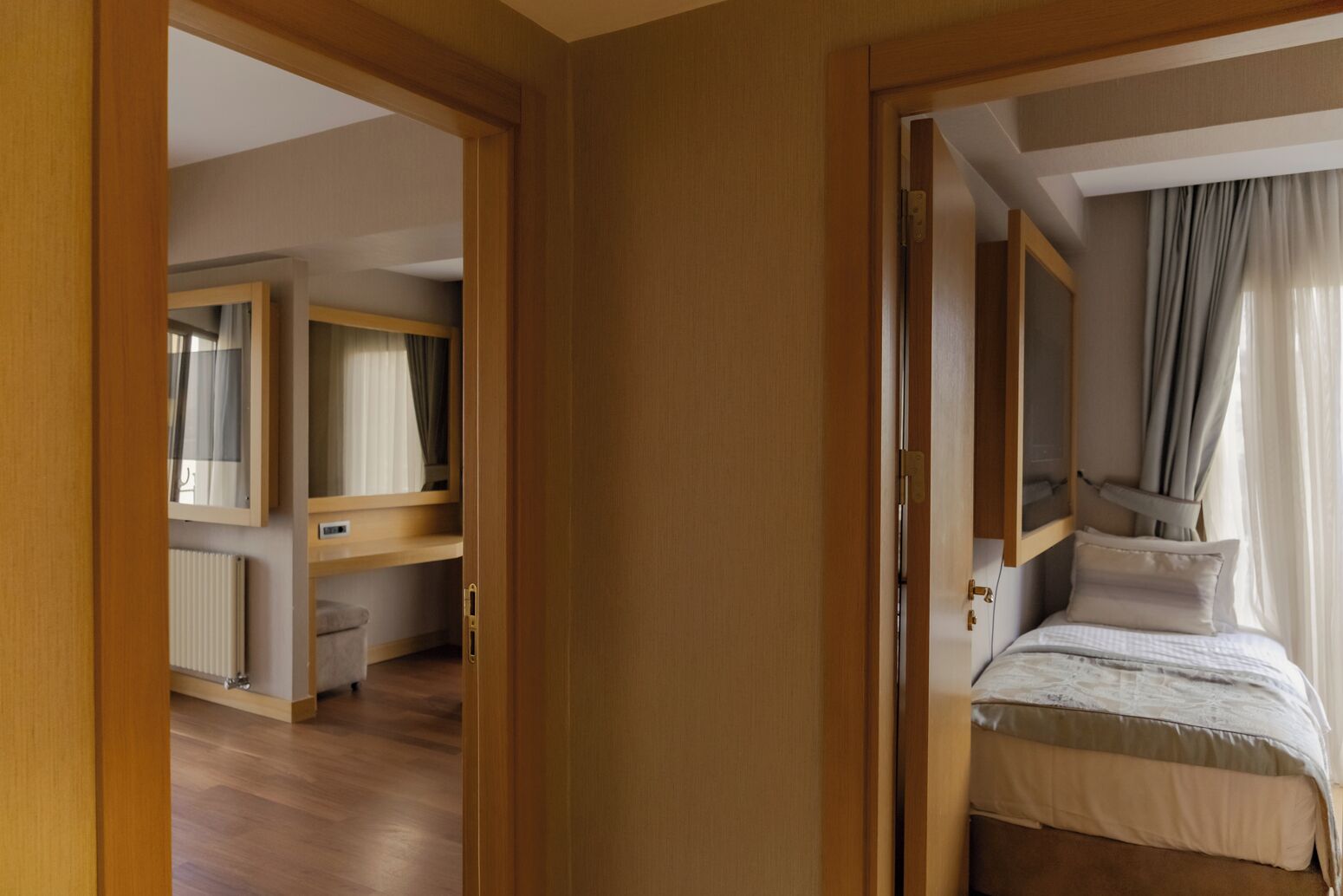 A bedroom with a bed, a bedside table, a mirror, and a wardrobe.