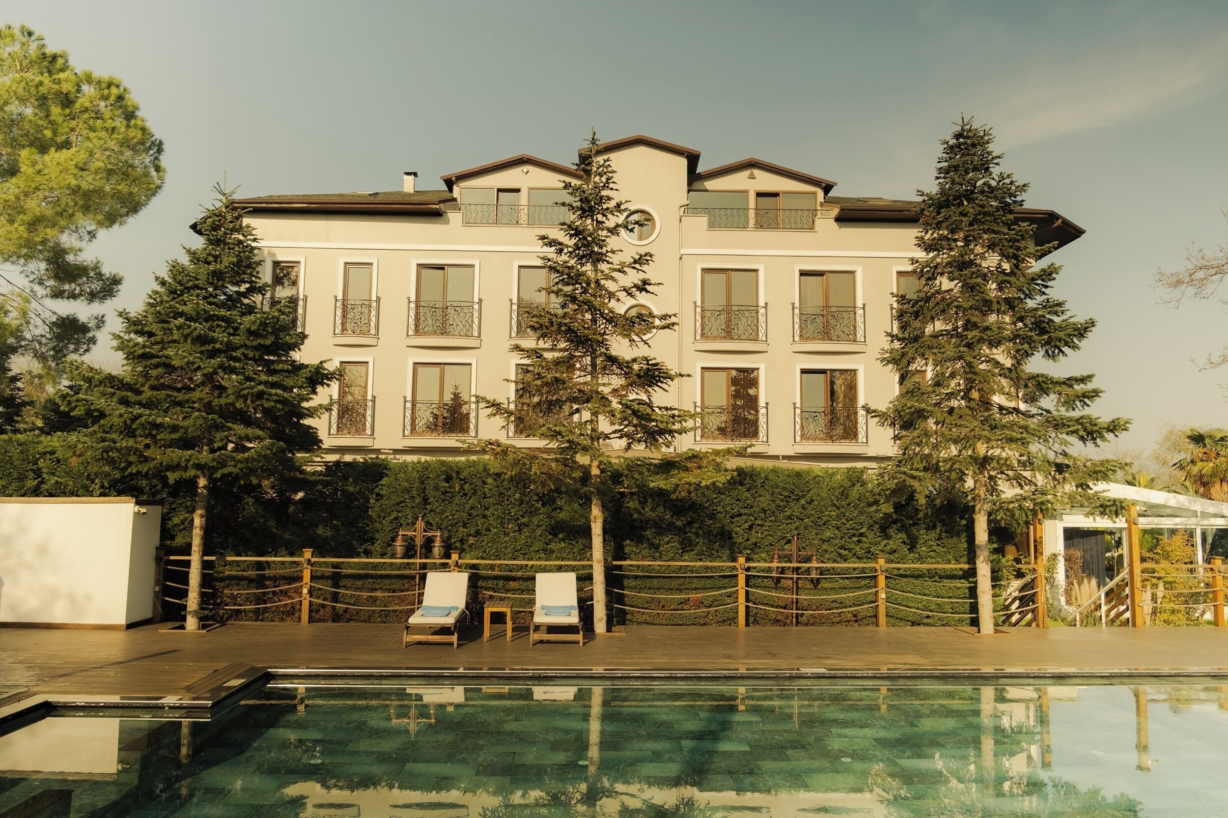 Una piscina al aire libre, sombrillas, tumbonas