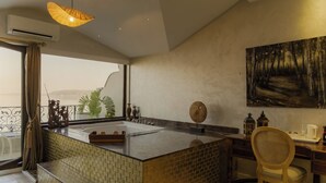 A modern kitchen with a central island, a dining area with a chair, and a large painting on the wall. - Lale Boutique Hotel (Sapanca)