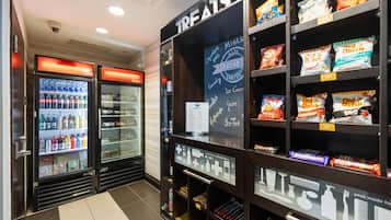 Zona de venta automática con bebidas y aperitivos, y un letrero que dice 'TREATS'.