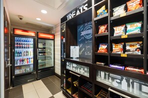 Zona de venta automática con bebidas y aperitivos, y un letrero que dice 'TREATS'.