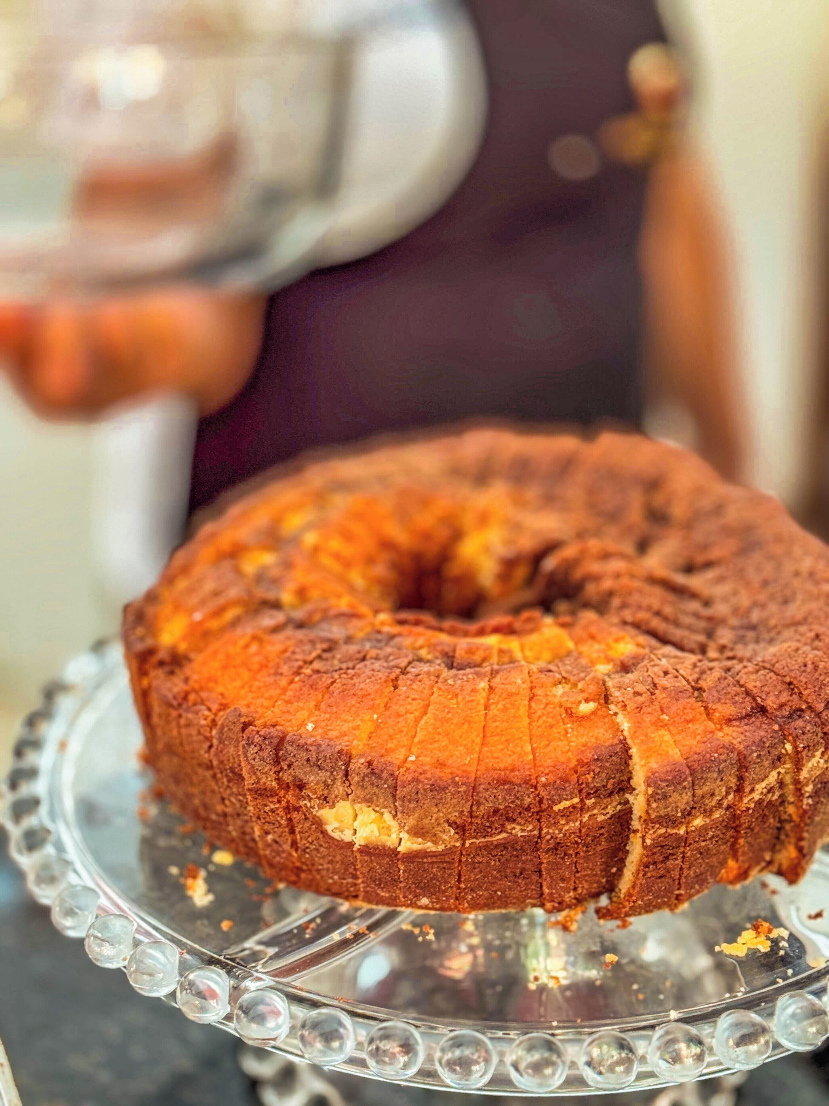 A bundt cake on a clear glass cake stand.