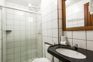 Chuveiro, toalhas de banho, sabonete, papel higiênico