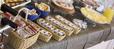 A buffet with various food items including pastries, cakes, and sushi.