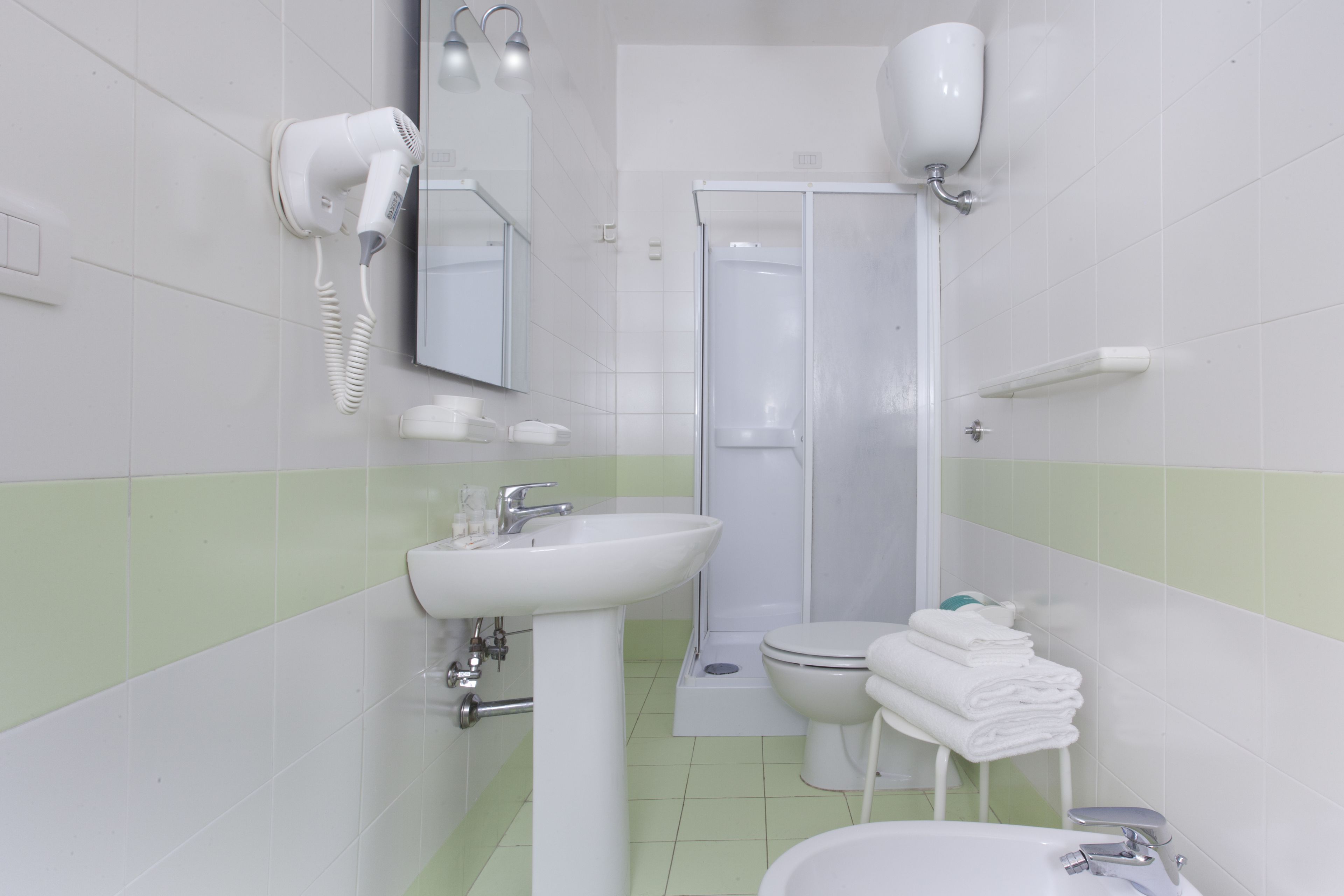 A bathroom with a sink, toilet, and shower.