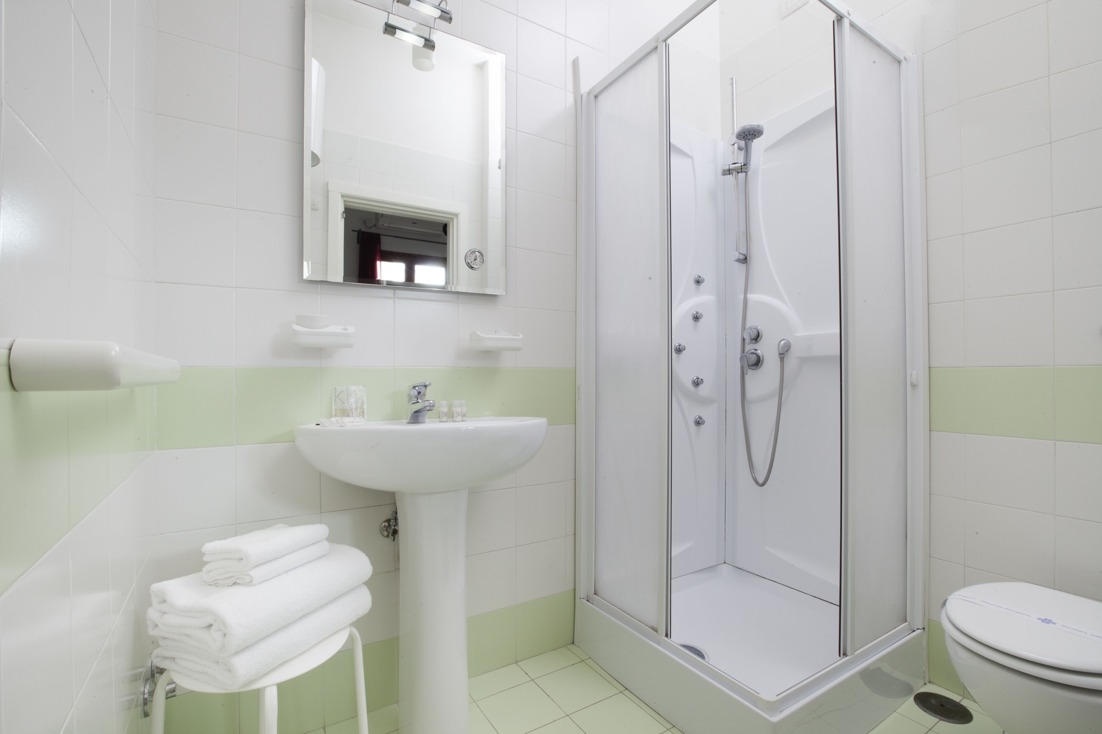 A bathroom with a shower, sink, and toilet.