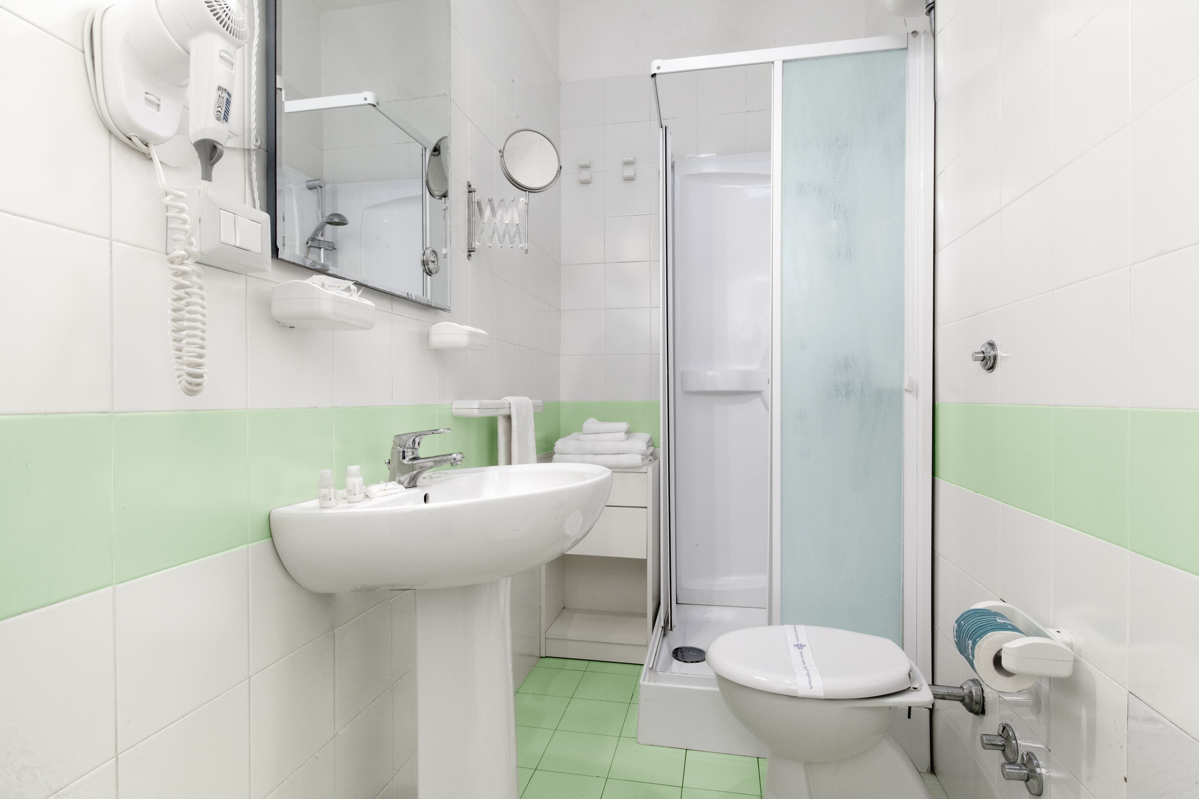 A bathroom with a sink, toilet, and shower.