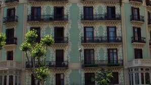 A multi-story building with ornate architectural details, balconies with black railings, and a curved facade. - Hostalin Diputacion (Barcelona)
