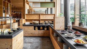 Una cocina moderna con muebles de madera y encimera negra, que muestra diferentes alimentos y utensilios.