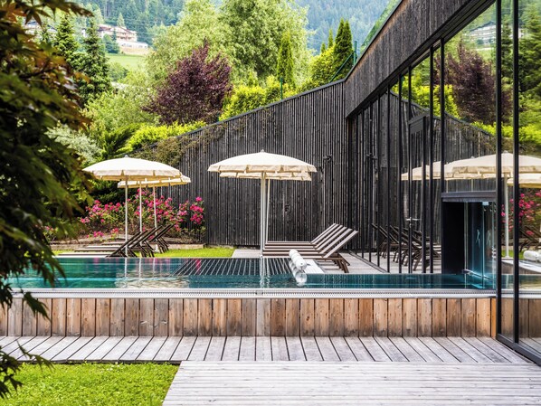 Piscine couverte, piscine extérieure, parasols de plage, chaises longues