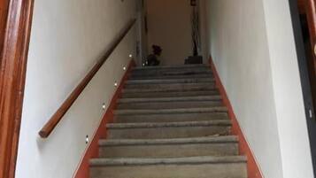 Una scala con ringhiera in legno e parete decorata di rosso.