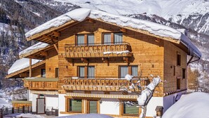 A wooden chalet with a balcony, surrounded by snow-covered mountains. - Aliona Apart (Soelden)