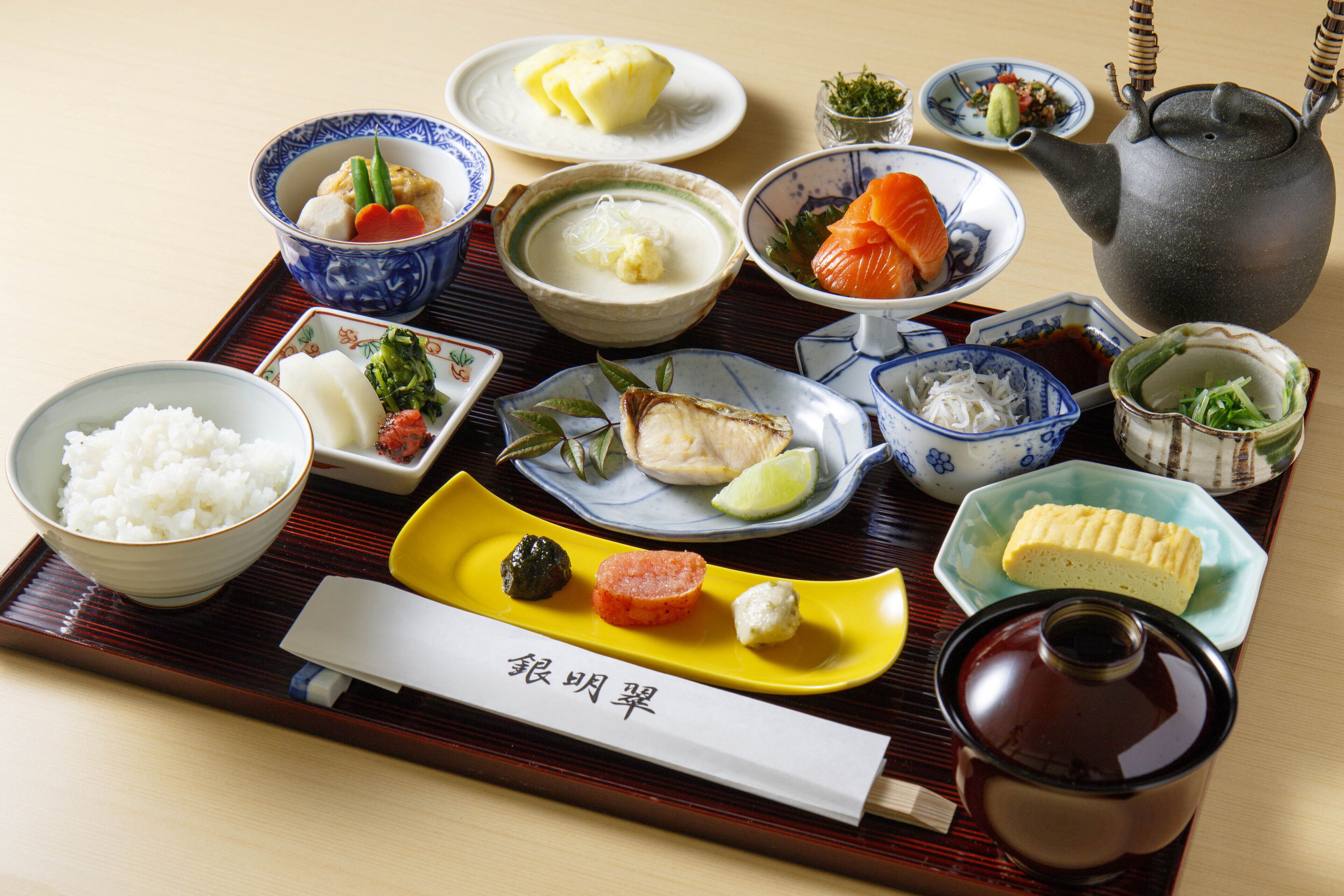 A traditional Japanese meal with various dishes and a teapot on a tray.